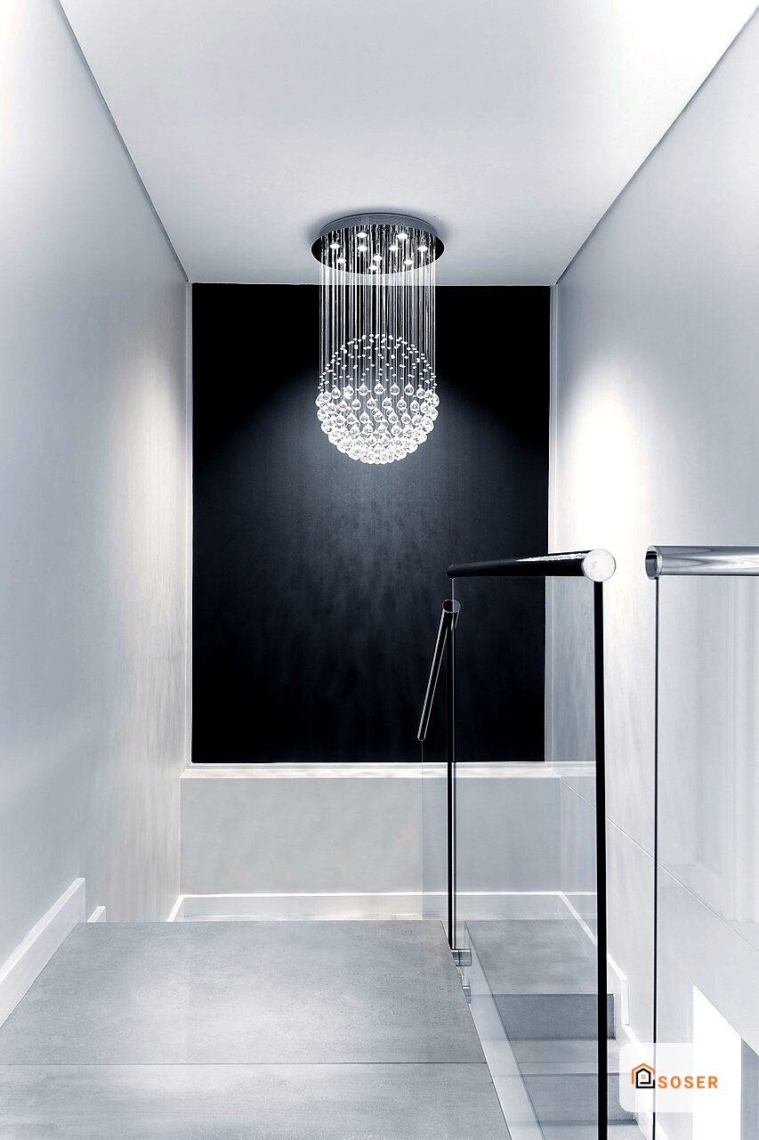 Bagno moderno con doccia a pioggia in cristallo, parete nera e rivestimento bianco