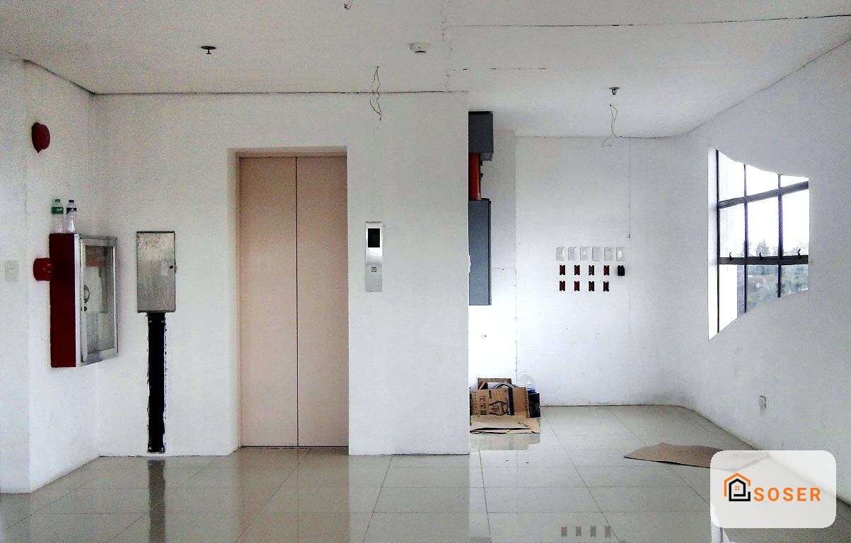Interno di appartamento in fase di ristrutturazione con pareti bianche, pavimento in piastrelle e impianti visibili