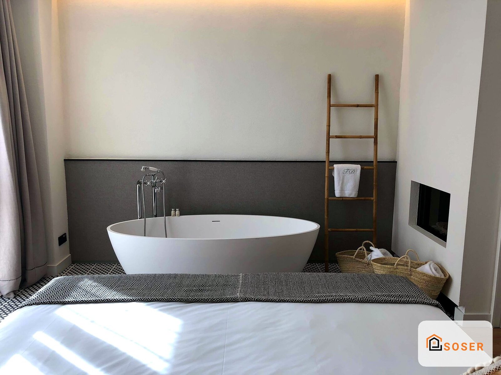Bagno moderno con vasca freestanding bianca, rivestimento nero, pavimento geometrico e scala in legno