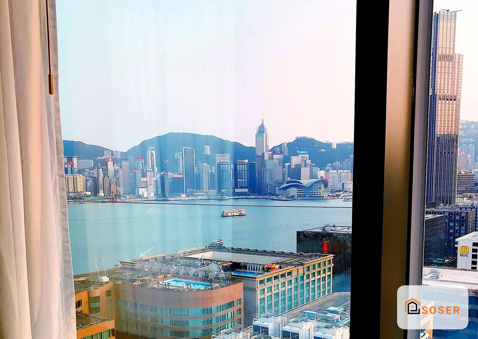 Vista panoramica di Hong Kong con skyline, grattacieli e baia dall'interno di un appartamento con finestre moderne