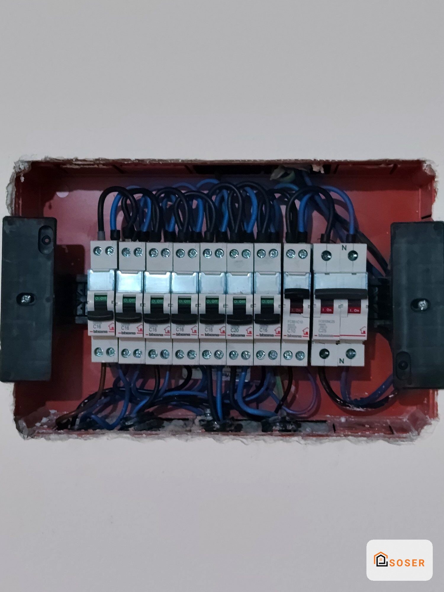 Quadro elettrico con interruttori automatici e cavi blu in scatola rossa