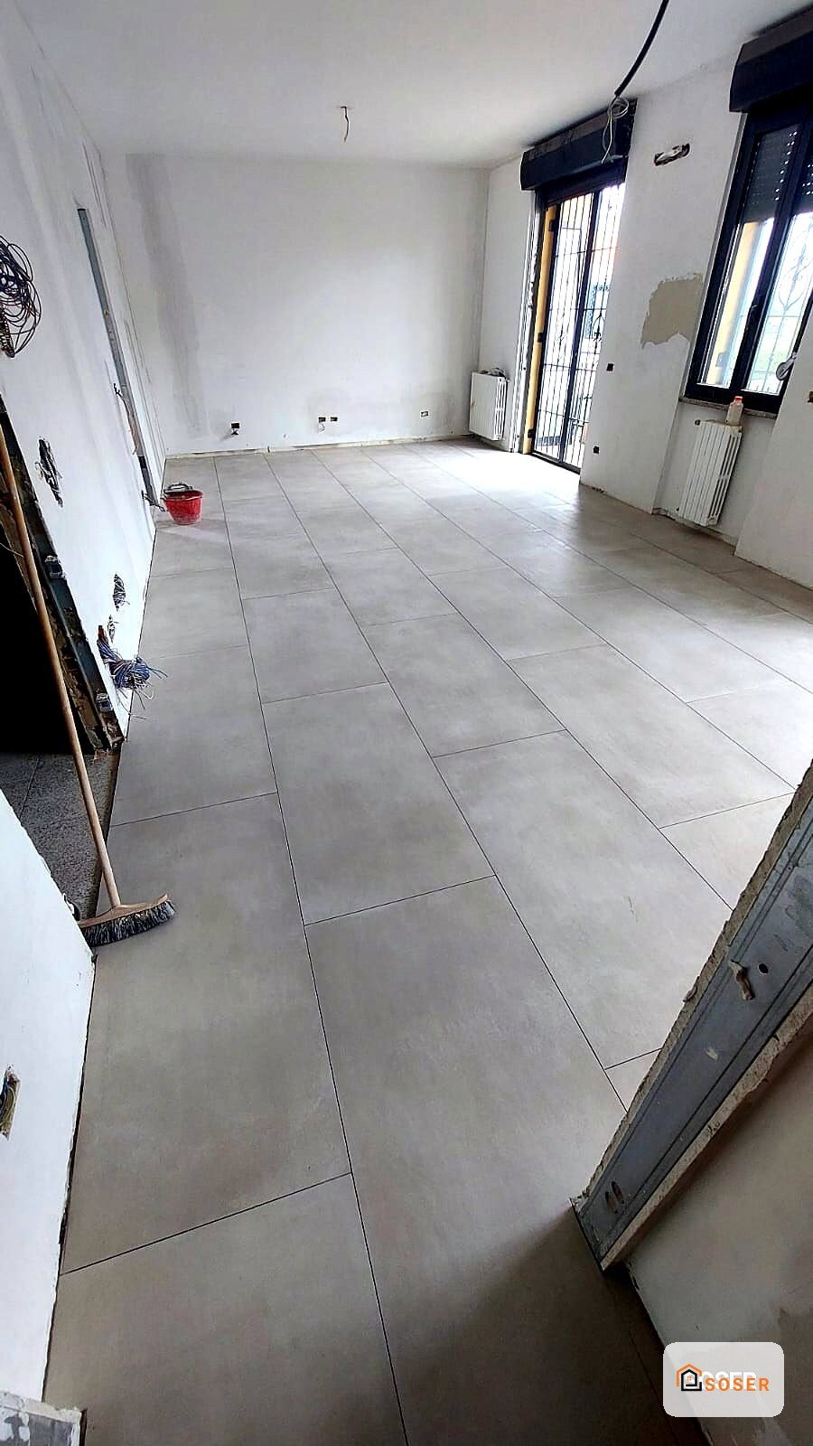 Soggiorno con pavimento in gres porcellanato grigio durante lavori di ristrutturazione