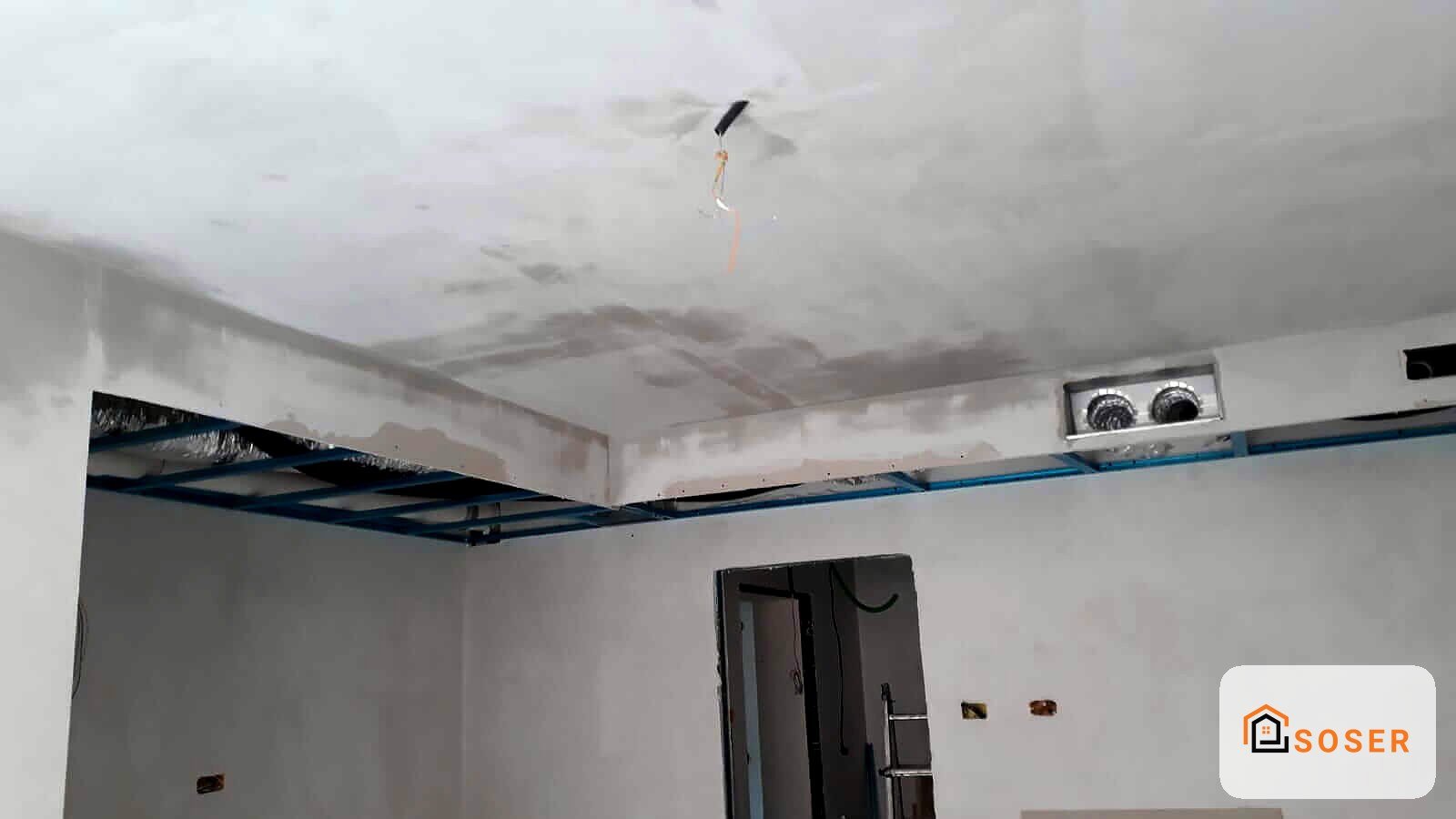 Cartongesso in fase di installazione su soffitto con struttura metallica blu e impianto elettrico visibile
