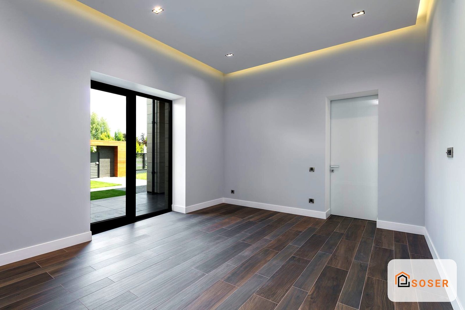 Soggiorno moderno con pavimento in legno scuro, pareti bianche e soffitto con illuminazione LED a Milano