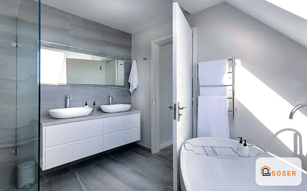 Bagno moderno ristrutturato con doppio lavabo bianco, specchio grande e vasca bianca, pavimento grigio scuro