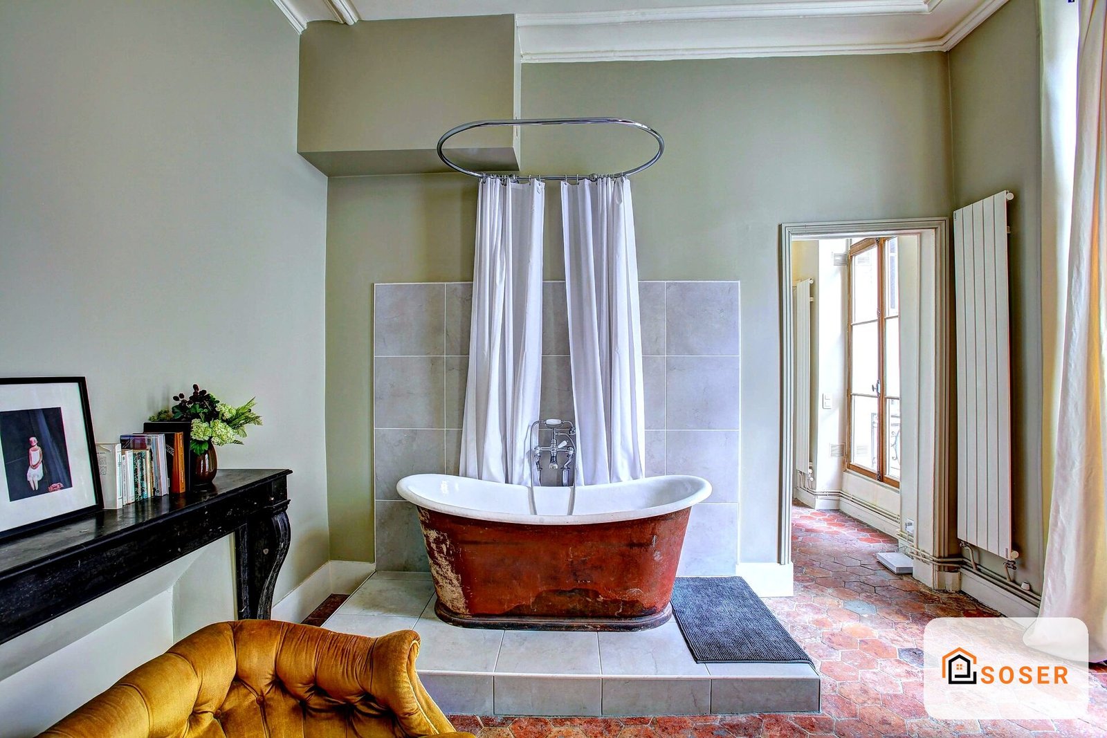 Bagno di lusso con vasca freestanding rossa, rivestimenti in pietra grigia e arredamento elegante