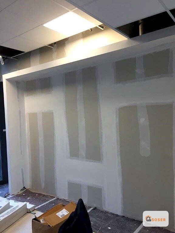 Parete in cartongesso con illuminazione a soffitto in una stanza in fase di costruzione a Milano