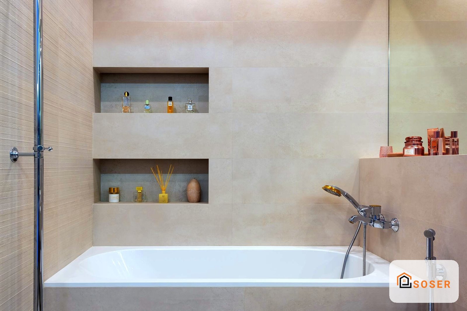 Bagno moderno con vasche da bagno bianca, nicchie a muro con prodotti beauty e finiture in tonalità beige