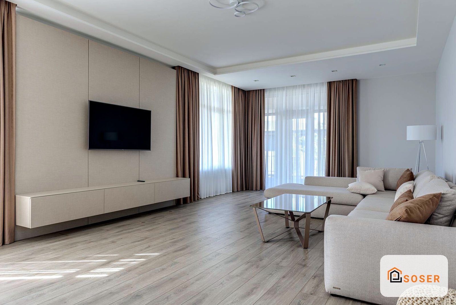 Soggiorno moderno con pareti in cartongesso, TV a parete e ampio divano grigio