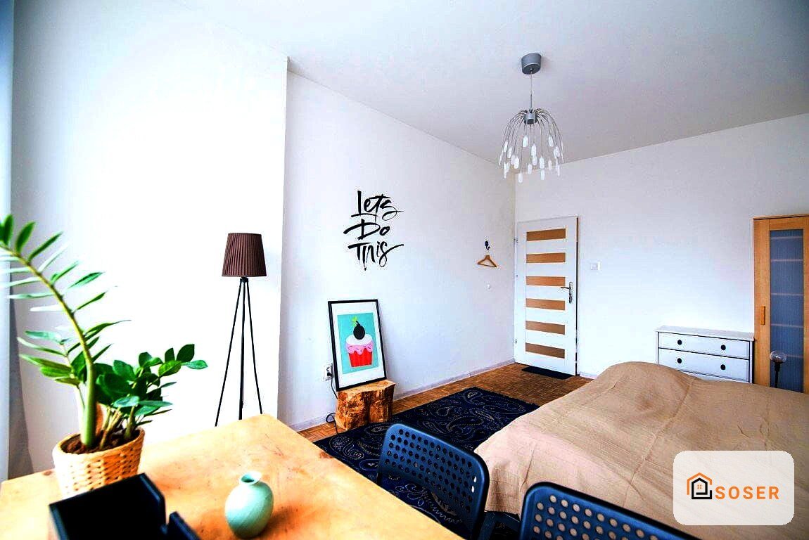Camera da letto moderna con pareti bianche, pavimento in legno e infissi in legno naturale