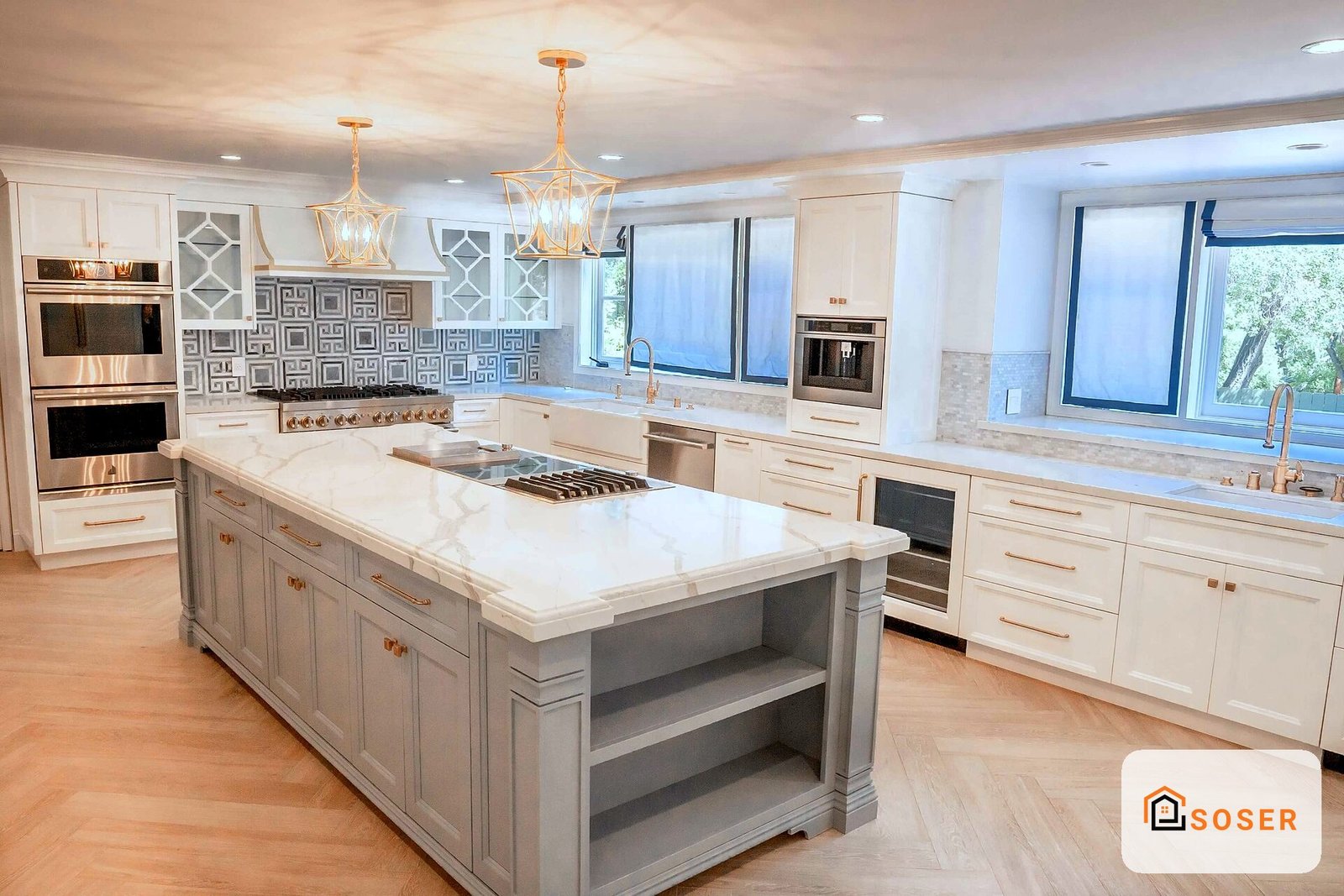 Cucina moderna di lusso con isola centrale, ante bianche, penisola grigia, top in marmo bianco e plafoniere dorate