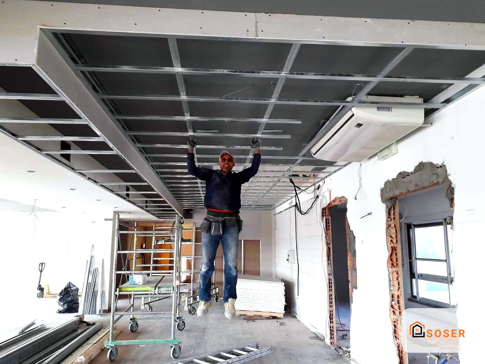 Operaio installa controsoffitto in cartongesso con struttura metallica in appartamento in ristrutturazione a Milano
