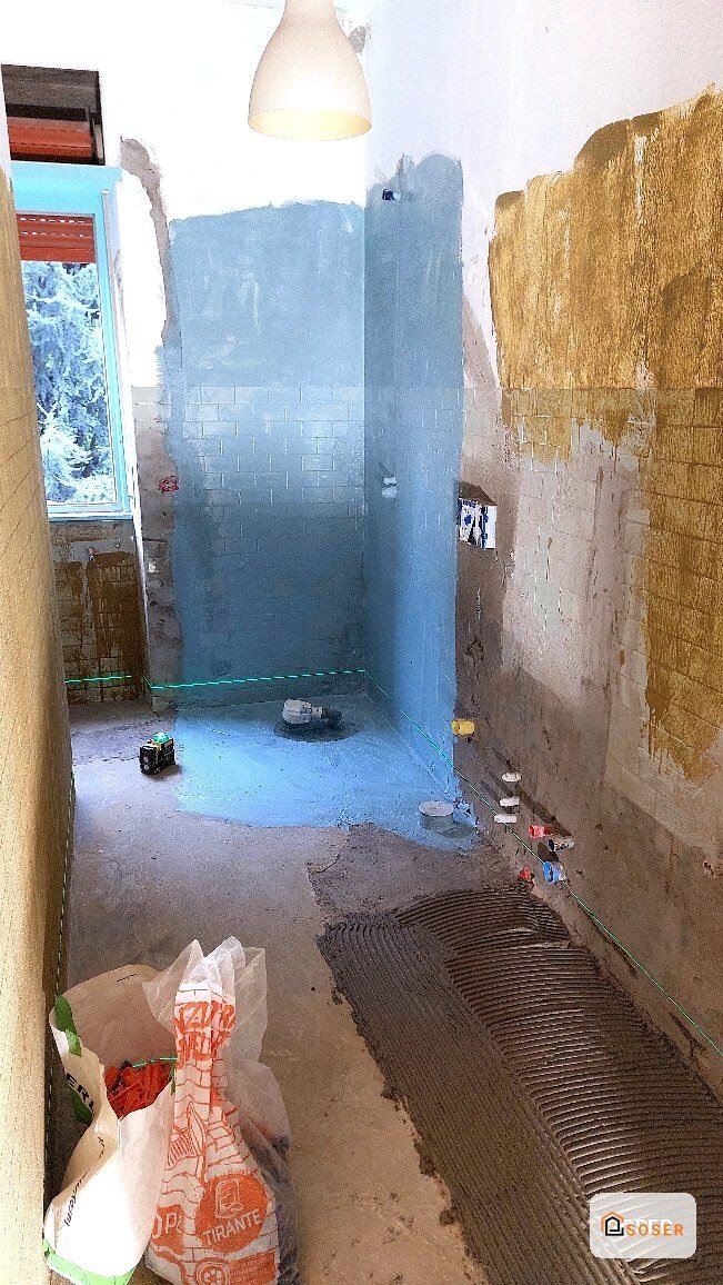 Bagno in ristrutturazione con pareti in cartongesso blu e preparazione per piastrellatura