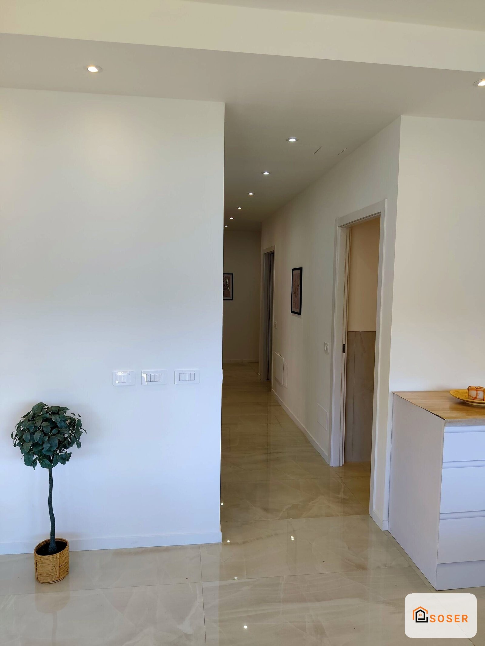 Corridoio moderno con pavimento in marmo, pareti bianche, impianto elettrico e porte interne in stile contemporaneo
