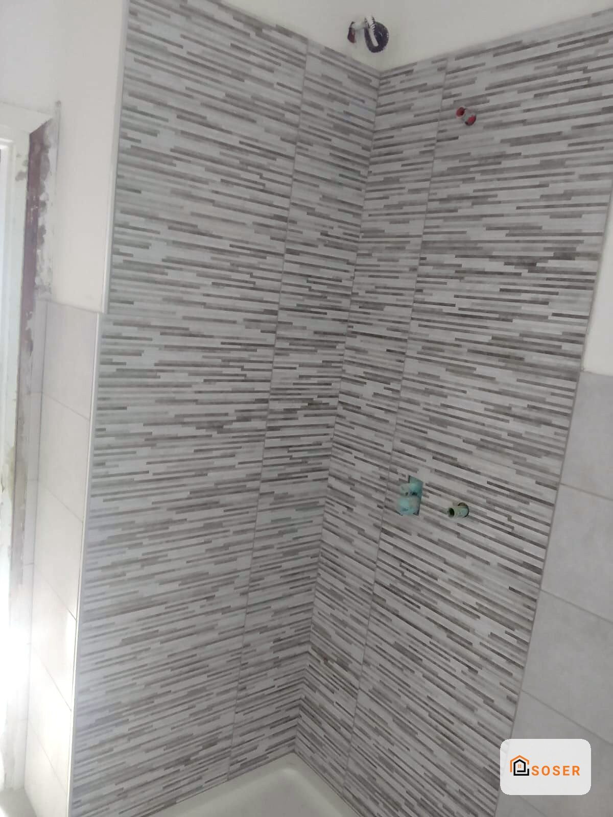 Rivestimento bagno con piastrelle a listelli grigio e bianco in stile moderno