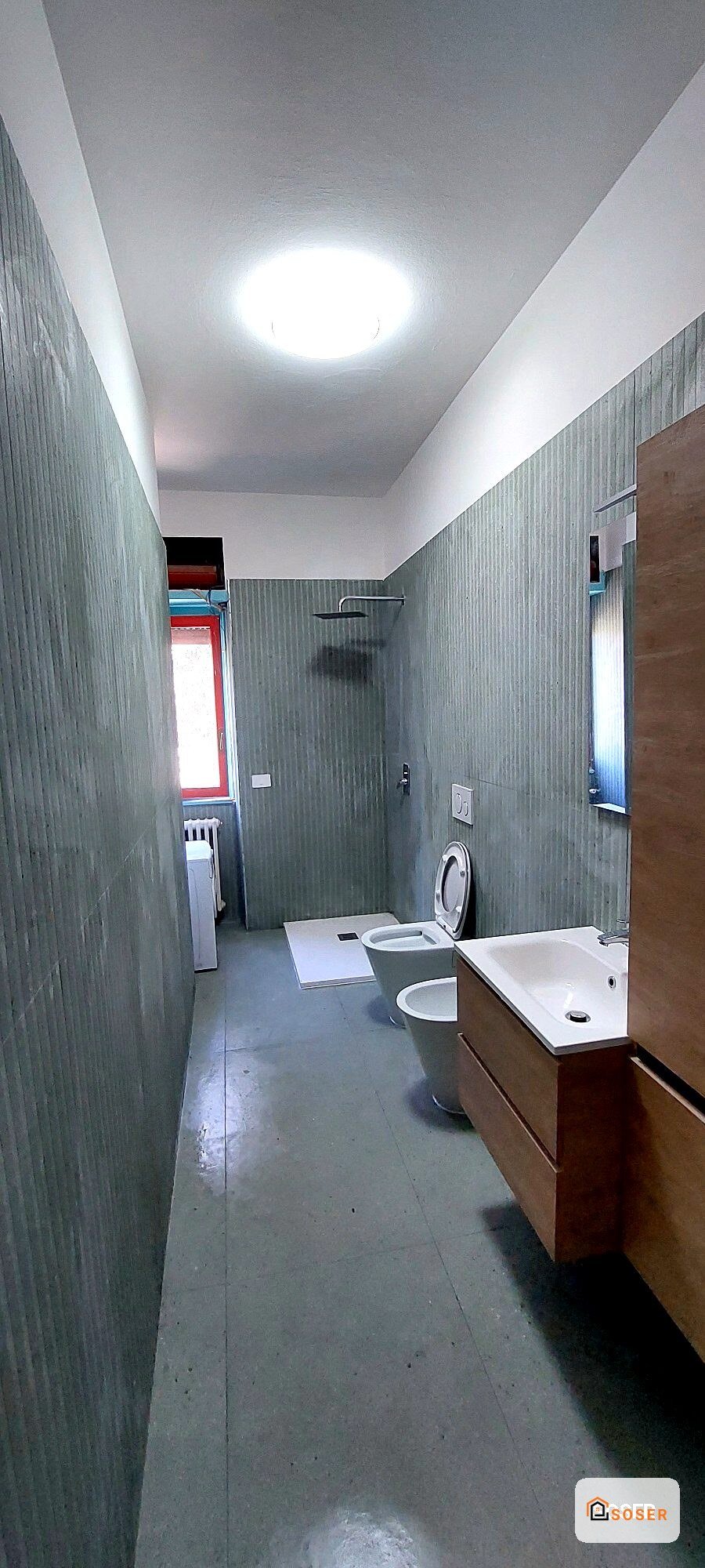 Bagno moderno con pareti grigie in cartongesso, lavabo in legno, toilette e doccia