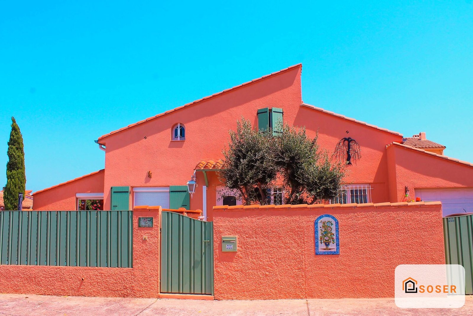 Facciata di casa moderna in stile contemporaneo con parete esterna rossa e dettagli verdi