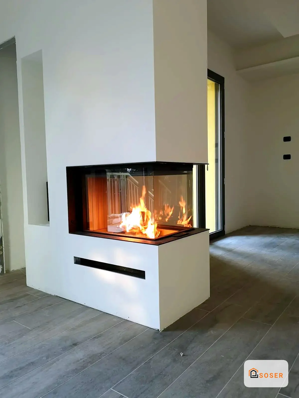 Camino moderno con inserto in vetro e cornice nera in ambiente minimalista con pareti bianche
