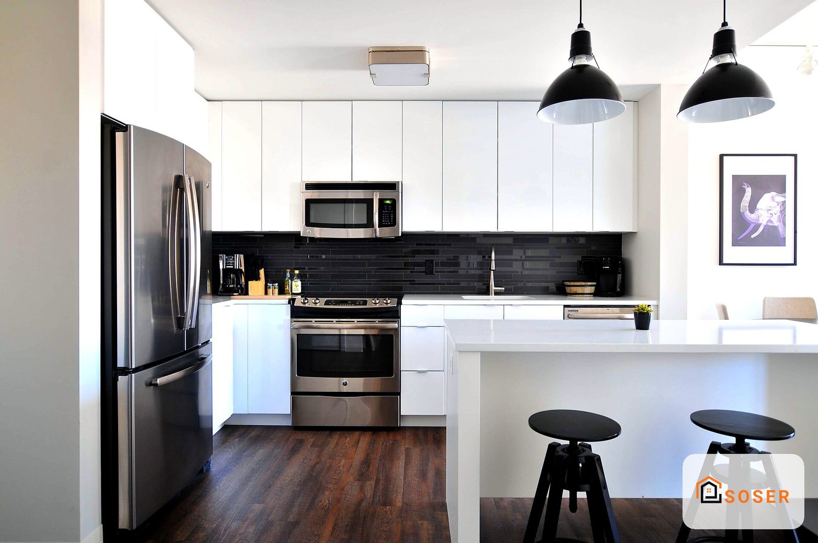 Cucina moderna con mobili bianchi, elettrodomestici in acciaio inox e isola centrale con sgabelli neri