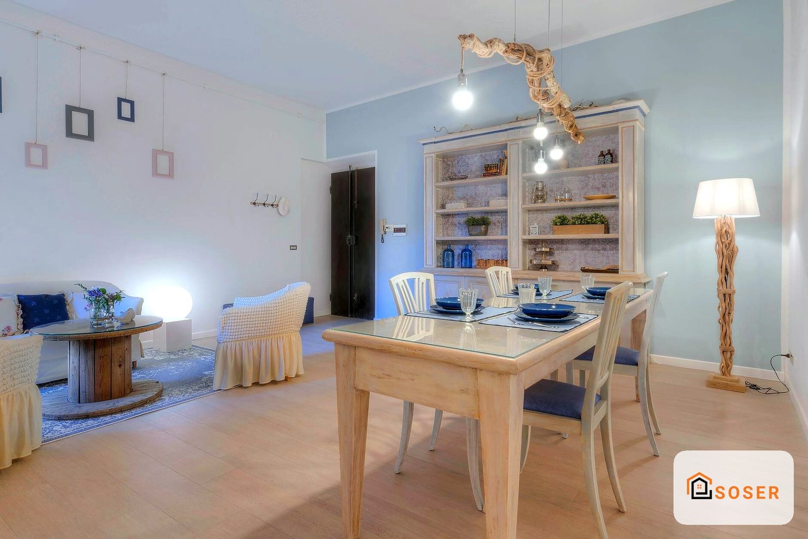 Sala da pranzo e living ristrutturati con pareti azzurre, pavimenti in legno e arredamento moderno