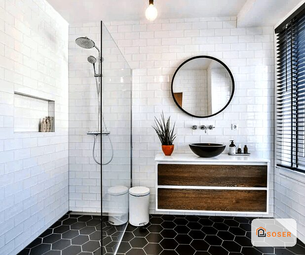 Bagno moderno con lavabo in legno, specchio circolare e piastrelle bianche e nere