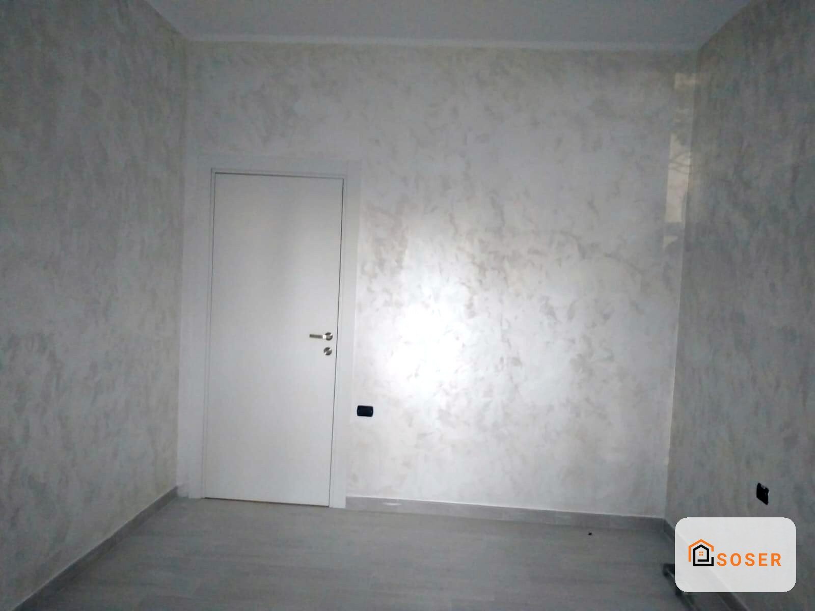 Stanza vuota con pareti in cartongesso e porta bianca, impianto elettrico in fase di realizzazione