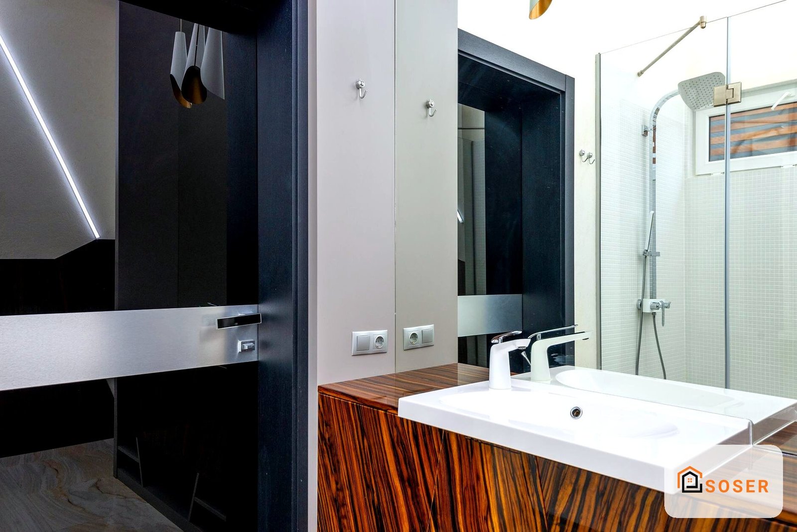 Bagno moderno con lavabo bianco, specchio nero, doccia con box in vetro e mobili in legno scuro
