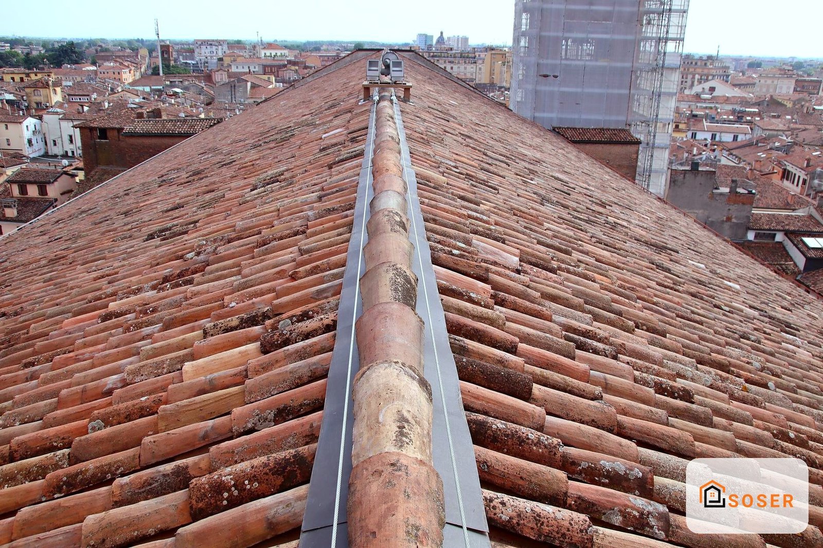 Tetto in coppi di terracotta con grondaia metallica vista dall'alto su città storica