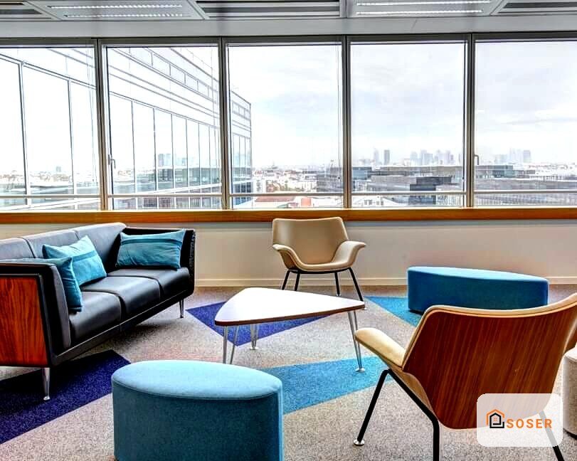 Sala d'attesa moderna con infissi in alluminio, divano grigio e sedie design con vista panoramica di Milano