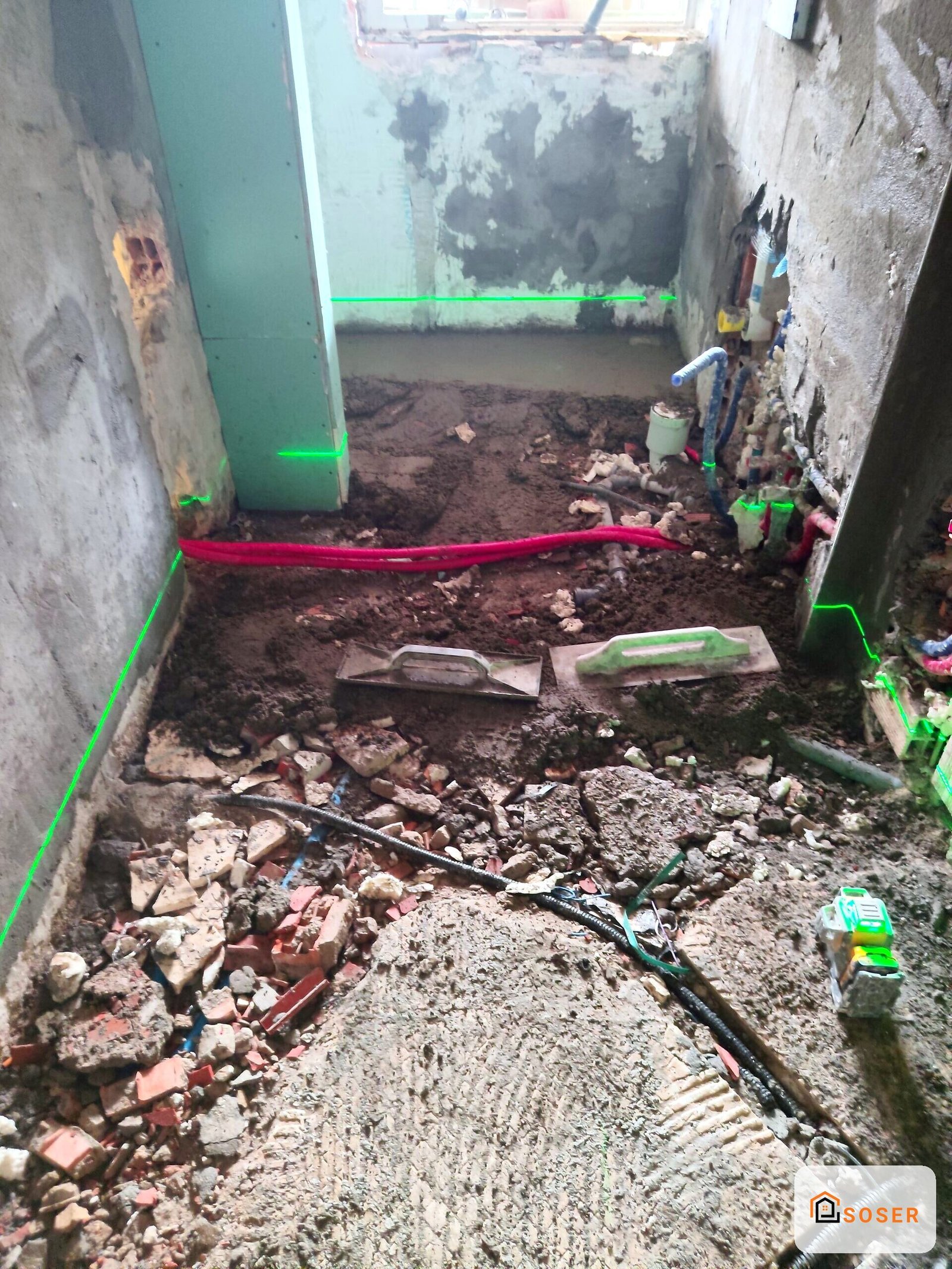 Demolizione e rimozione macerie in corridoio con pareti in cemento durante ristrutturazione