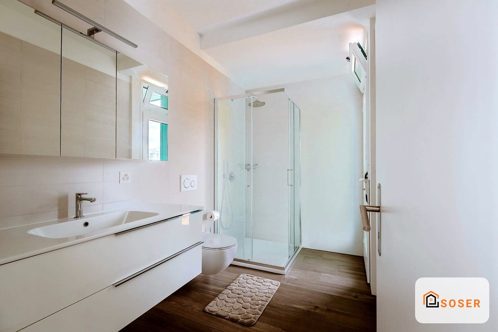 Bagno moderno con lavabo bianco, specchio, doccia in vetro e pavimento in legno