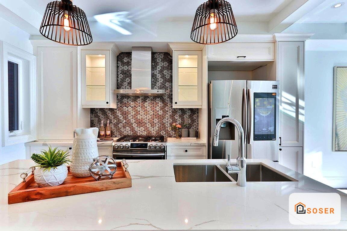 Cucina moderna con isola centrale, penisola bianca, elettrodomestici acciaio e backsplash geometrico scuro