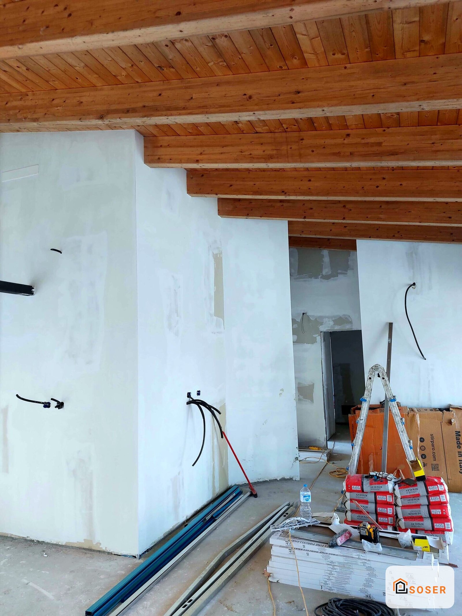 Cantiere di ristrutturazione con pareti in cartongesso bianco e impianto elettrico in allestimento