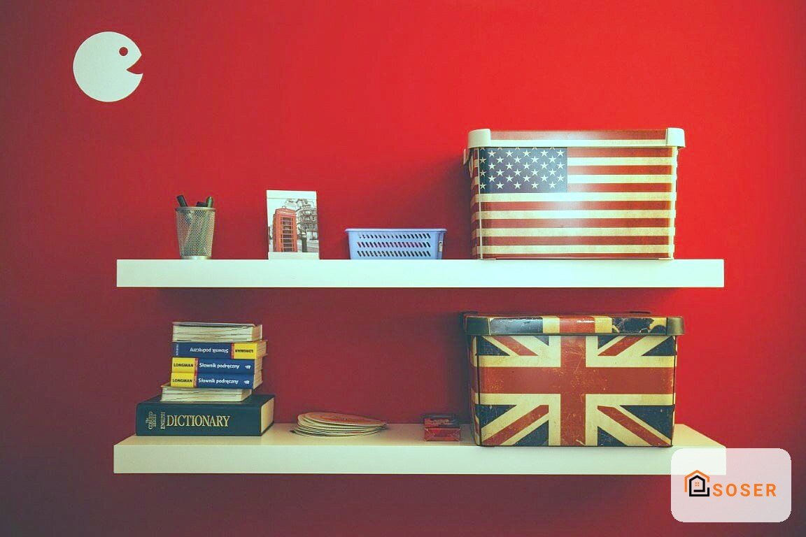 Parete rossa con due scaffali bianchi decorati con libri, scatole e accessori vintage