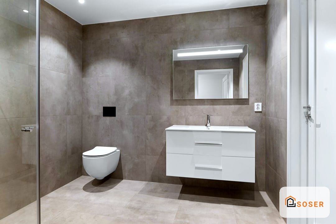 Bagno moderno con rivestimento in gres porcellanato grigio, vanity bianca sospesa e specchio illuminato