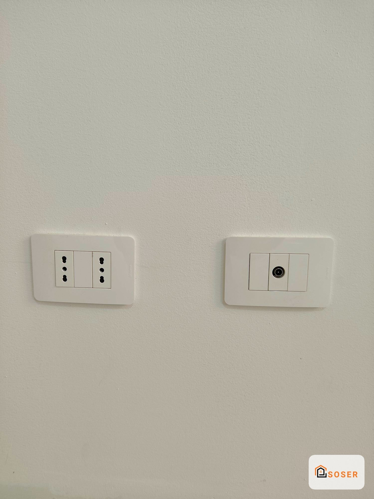 Interruttori e prese elettriche bianche moderne su parete bianca