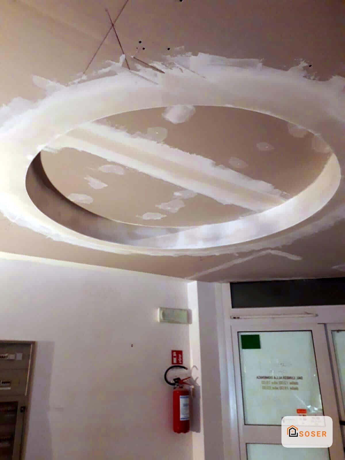 Controsoffitto in cartongesso circolare con intonaco in fase di finitura, in ambiente interno con impianti
