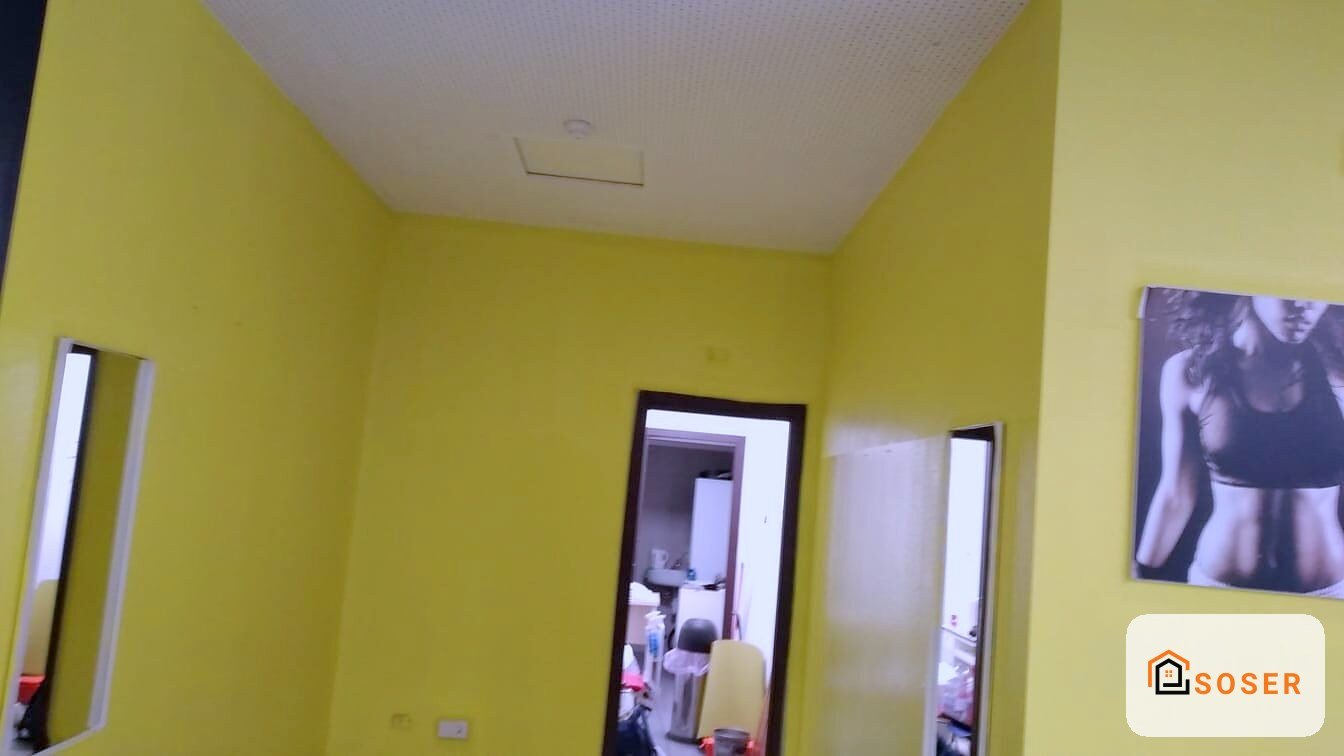 Camera da letto con pareti gialle e soffitto bianco, specchio e porte in una ristrutturazione