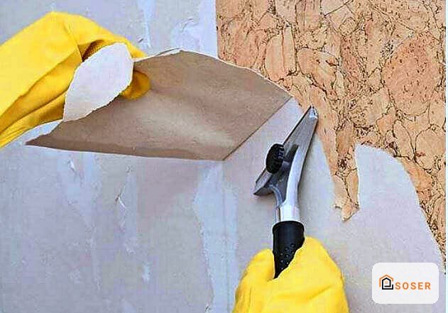 Operaio applica stucco e spatola su parete per imbiancatura e finitura, lavori di ristrutturazione