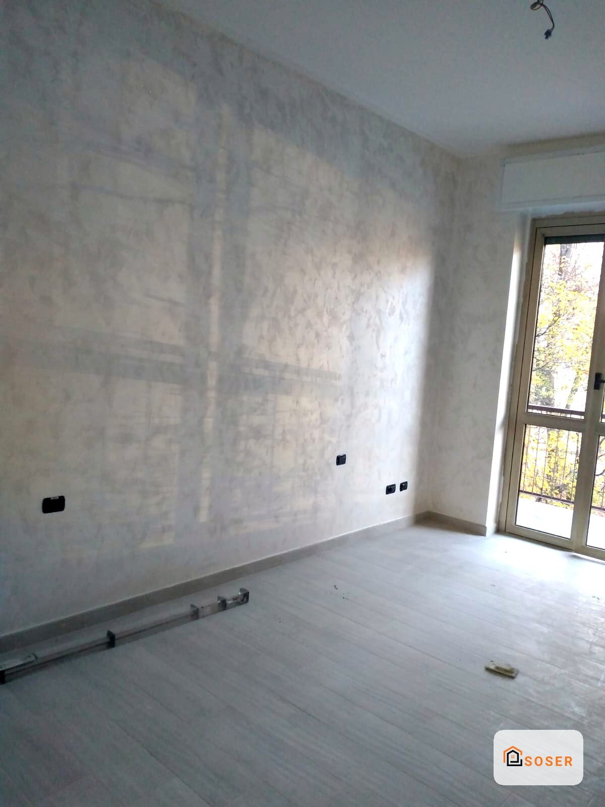 Stanza in fase di ristrutturazione con pareti in cartongesso e pavimento in levigato a Milano