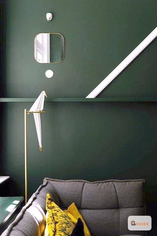 Parete verde salvia con imbiancatura moderna, lampada a sospensione e specchio rotondo in soggiorno contemporaneo
