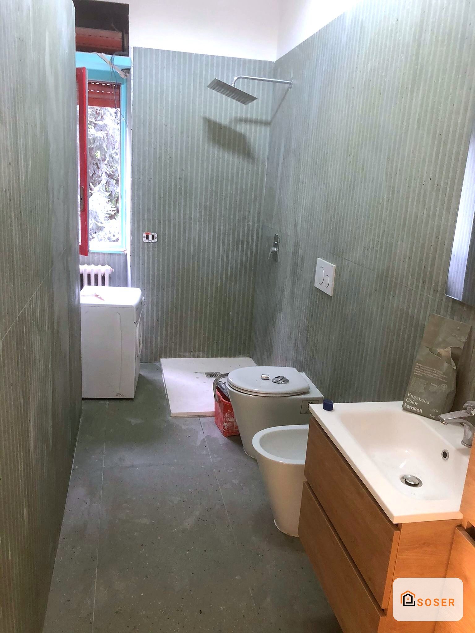 Bagno in ristrutturazione con rivestimenti in gres, sanitari nuovi e doccia moderna a Milano