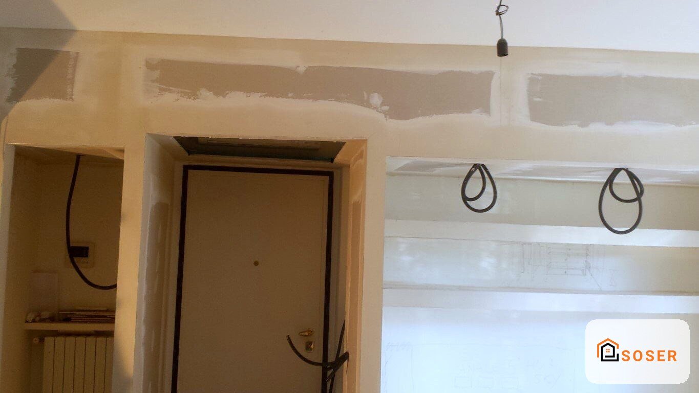 Cantiere di ristrutturazione con pareti in cartongesso e impianto elettrico a vista