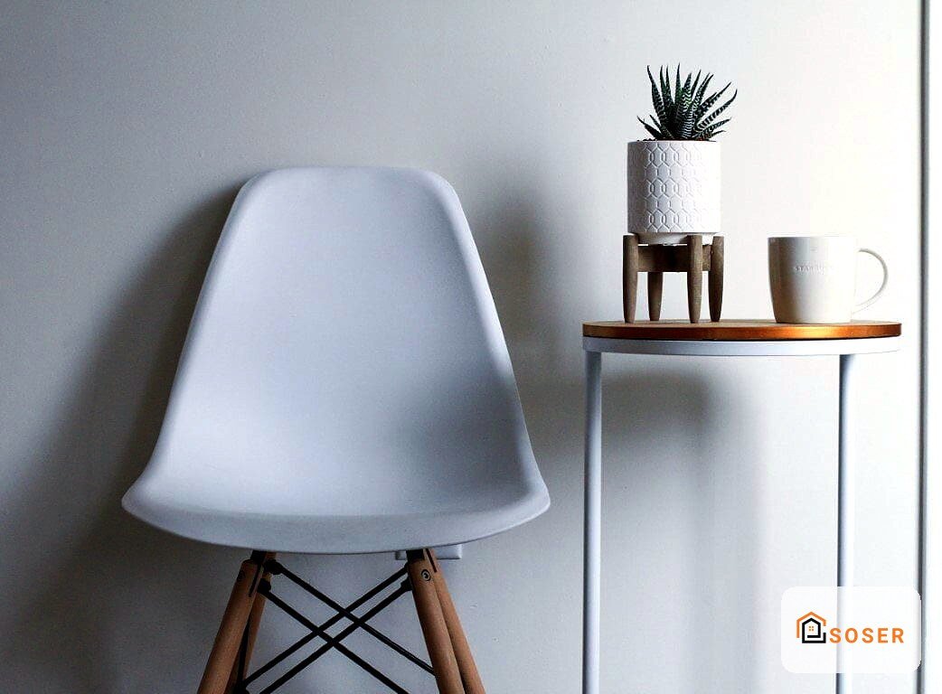 Interno moderno con sedia bianca Eames, tavolino in legno e parete imbiancata
