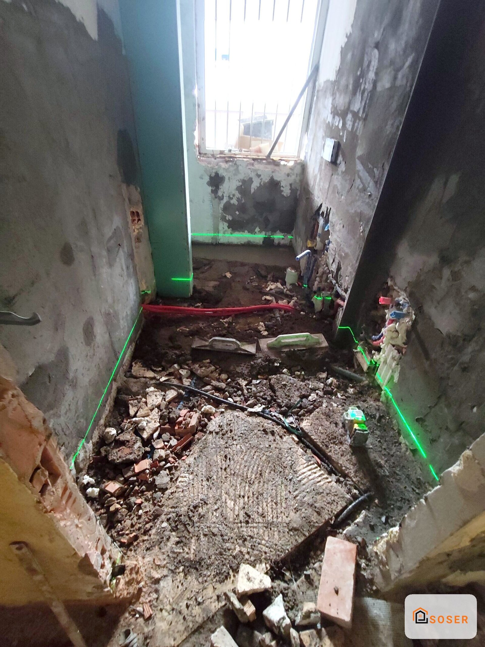 Scavo e demolizione interno di casa con pareti deteriorate e detriti, preparazione per ristrutturazione