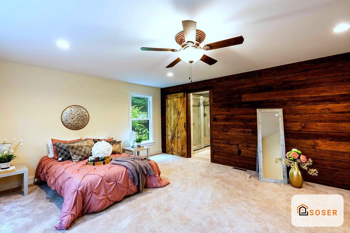 Camera da letto moderna con pareti in legno, letto rosa, ventilatore a soffitto e pavimento in moquette