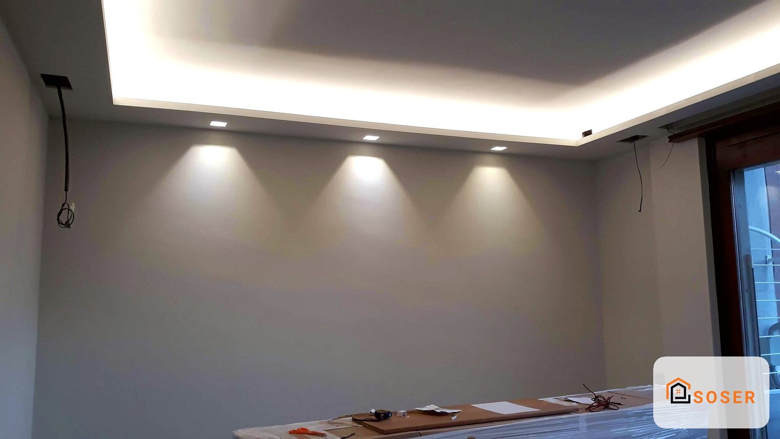 Controsoffitto in cartongesso con illuminazione a led integrata e faretti in una stanza moderna a Milano