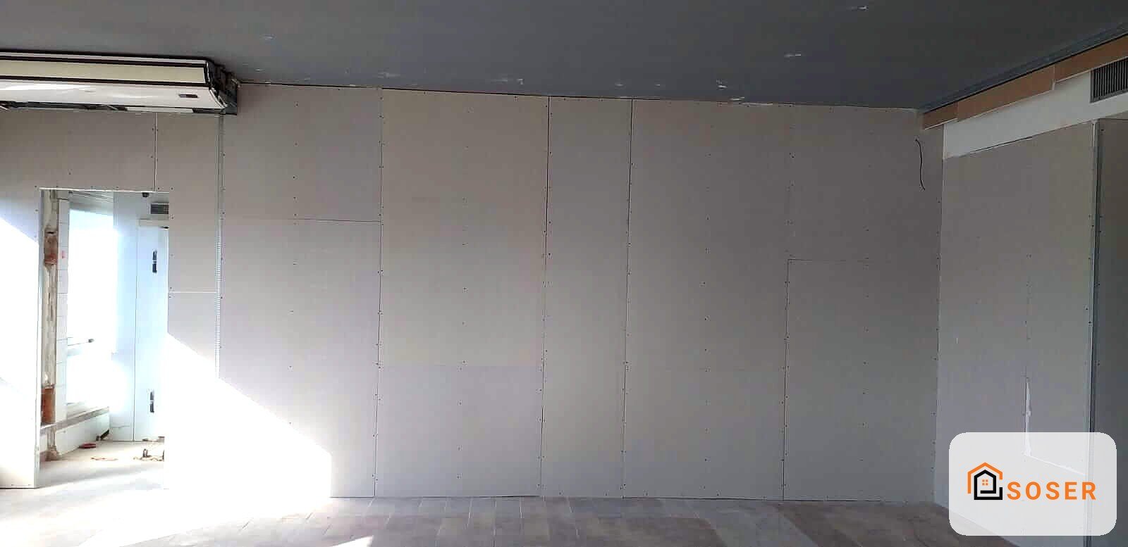 Stanza in cartongesso con pareti divisorie in fase di realizzazione, soffitto grigio e pavimento grigio