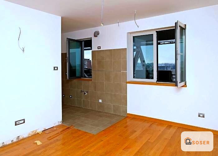 Bagno in ristrutturazione con pavimento in legno, piastrelle in ceramica marrone e infissi in legno