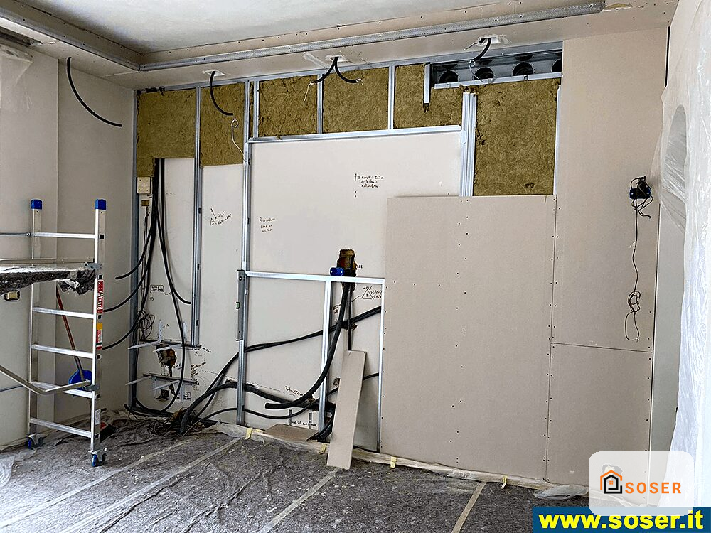Cantiere di ristrutturazione con pareti in cartongesso e impianti elettrici in corso di installazione